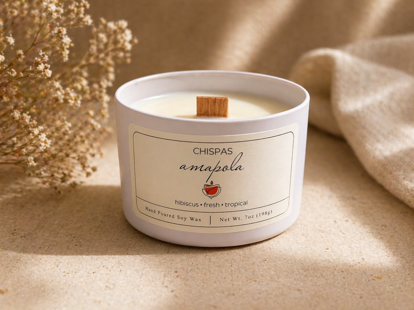 Amapola candle by Chispas with a wooden wick, styled in a soft neutral setting with delicate florals and warm natural lighting.